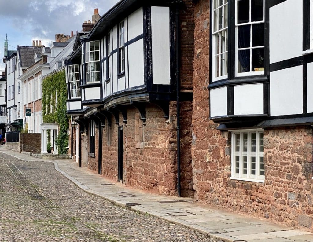 Traditional Tudor buildings in Exeter with black and white painted fronts and red brick walls