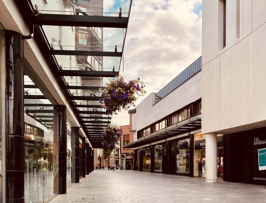 Princesshay shopping Centre in Exeter, a modern shopping centre with flower baskets hanging from the glass overhang
