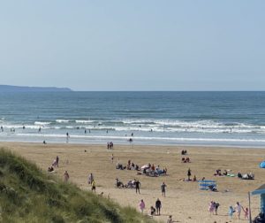 Saunton Sands beach in the summer with people surfing and sunbathing