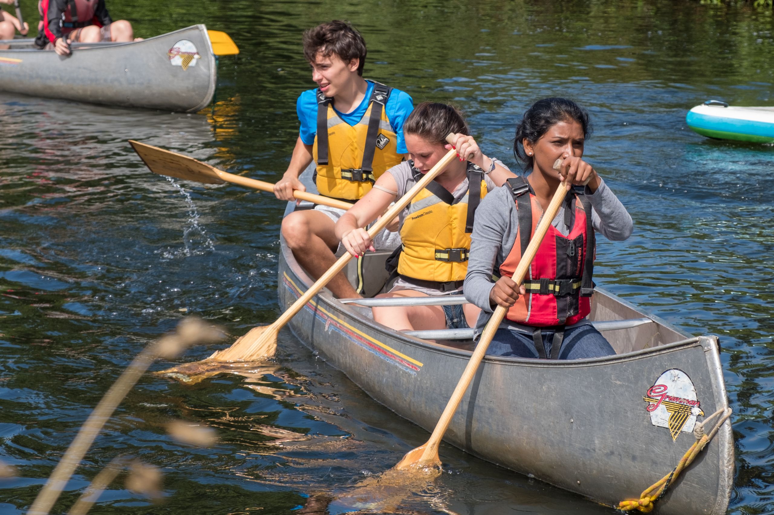 Teenagers learning English whilst canoeing on the River Exe, Exeter at Isca School Summer English course